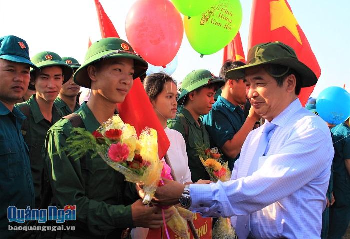 UVBTV Tỉnh úy Nguyễn Minh Tài tặng hoa, động viên các tân binh lên đường nhập ngũ.