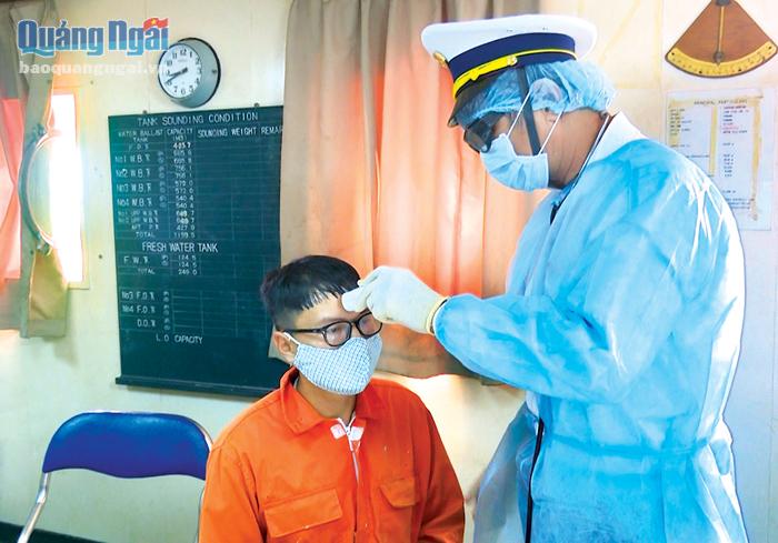 Bác sĩ Nguyễn Văn Hoàng (Trung tâm Kiểm soát bệnh tật tỉnh) kiểm tra thân nhiệt thủy thủ tàu nước ngoài cập cảng Dung Quất.