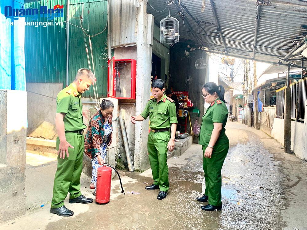 Lực lượng Công an xã Bình Hải (Bình Sơn) tuyên truyền, hướng dẫn người dân sử dụng bình chữa cháy.
