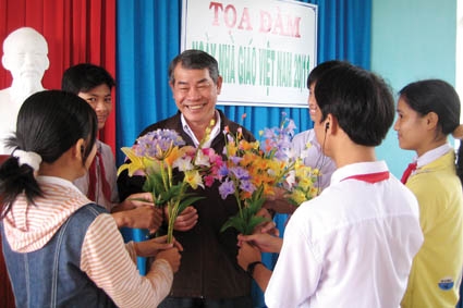  Thầy Lê Trung Tiên (giữa) bên những bông hoa do các em khuyết tật tự làm dâng tặng. 