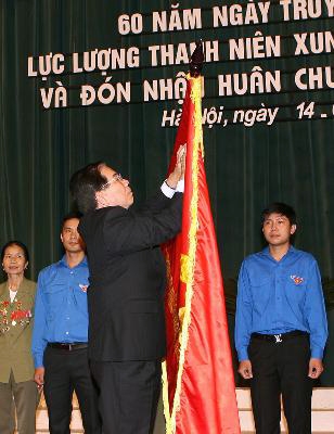 Chủ tịch nước Nguyễn Minh Triết gắn Huân chương Sao Vàng lên lá cờ truyền thống của lực lượng Thanh niên xung phong Việt Nam - Ảnh TTXVN 