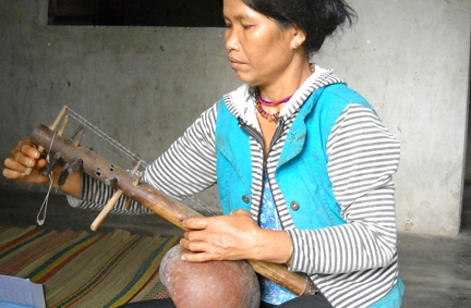  Nghệ nhân Đinh Thị Đê đang điều chỉnh thanh âm của cây đàn B’roat.      