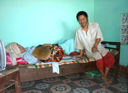 Ông Trần Kiệm nằm liệt giường và đứa con trai bị nhiễm chất độc da cam.