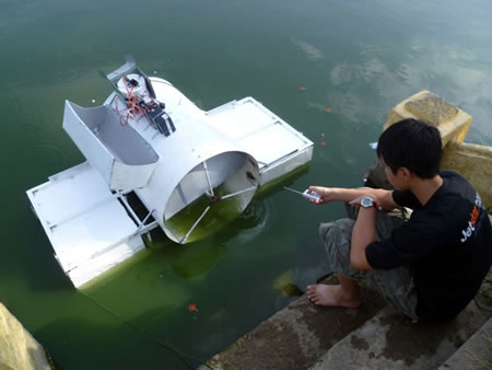 Đào Vạn Quang bên mô hình máy dọn rác thải trên nước.