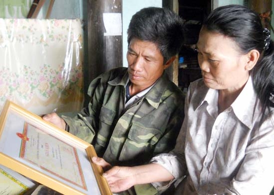 Vợ chồng anh Hoàng và chị Hoa tự hào với tấm giấy khen về thành tích học tập giỏi của các con.