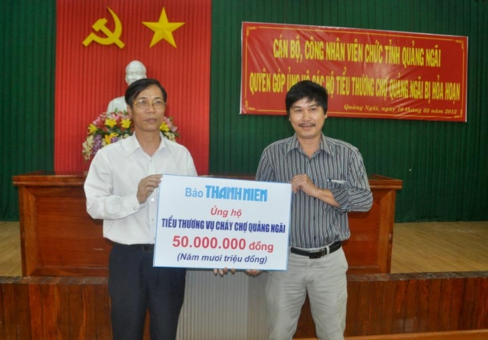 Đại diện báo Thanh Niên (phải) trao 50 triệu đồng cho UBMTTQVN tỉnh ủng hộ các tiểu thương.