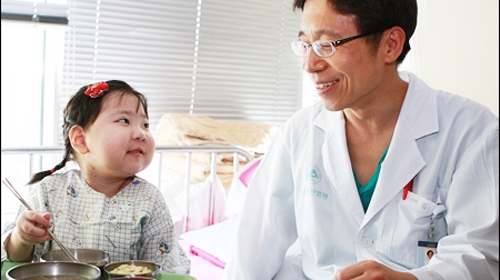 Bé Cho Eun Seo đã có thể tự ăn uống được. Bên cạnh là bác sĩ Kim Dae yeon, người đã góp phần hiện thực hóa giấc mơ của cô bé 7 tuổi này - Ảnh: Koreatimes