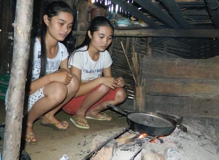 Sau khi đi học về hai chị em Lê Thị Bích Vy và Lê Thị Vân lại vào bếp nấu cơm