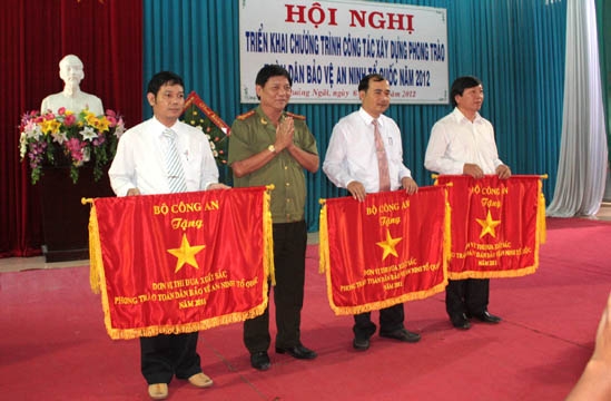 Đại tá Huỳnh Ngọc Phương - Cục phó Cục xây dựng phong trào, Bộ Công an trao Cờ thi đua xuất sắc năm 2011 của Bộ Công an cho các tập thể.