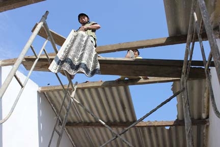 Gia đình anh Nguyễn Ngọc Lý đang lợp lại mái nhà