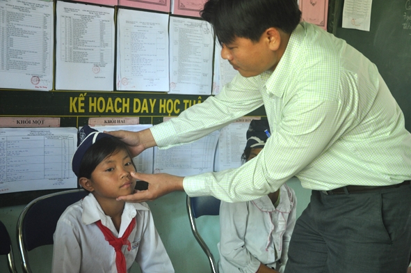 Bác sĩ Phạm Văn Trường, Trạm trưởng Trạm Y tế xã Sơn Ba kiểm tra tình hình bệnh của học sinh trường Tiểu học Sơn Ba