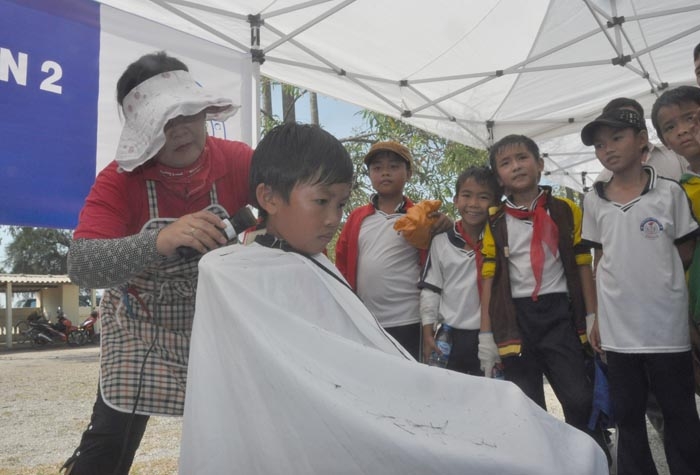 Các em học sinh thích thú khi được chính người Hàn Quốc cắt tóc cho các em.