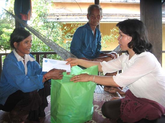 Chủ tịch Hội LHPN tỉnh Phạm Thị Thu Trang (bên phải) tặng quà cho phụ nữ mắc bệnh ở thôn Làng Rêu, xã Ba Điền.
