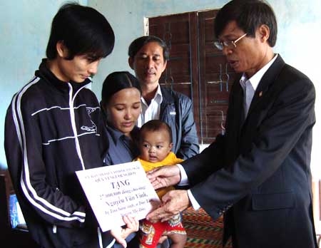 Chủ tịch UBMTTQVN tỉnh Nguyễn Minh Tuấn trao tiền hỗ trợ từ Quỹ vì Người nghèo tỉnh cho bệnh nhân nghèo.
