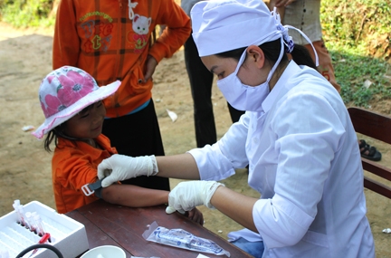 Số trẻ em mắc Hội chứng viêm dày sừng ngày càng tăng. Trong ảnh: Cán bộ y tế đang lấy mẫu máu xét nghiệm cho trẻ sống trong vùng dịch Ba Điền