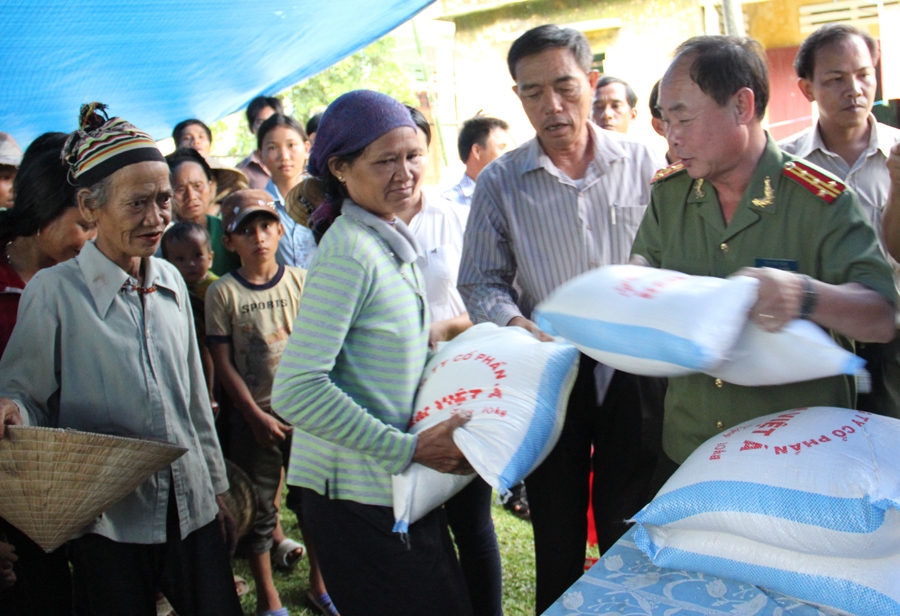 Đại tá Trần kim Thẩm, Phó TBT Báo CAND đang trao gạo, tiền hỗ trợ cho người dân Ba Điền