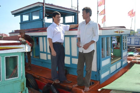 Bí thư Huyện ủy Lý Sơn Võ Xuân Huyện (trái) thăm hỏi ngư dân Nguyễn Văn Duyên chuẩn bị ra khơi đánh bắt.