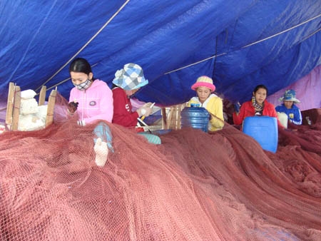 Phụ nữ nghèo huyện đảo Lý Sơn vá lưới thuê, kiếm thêm thu nhập cải thiện cuộc sống.