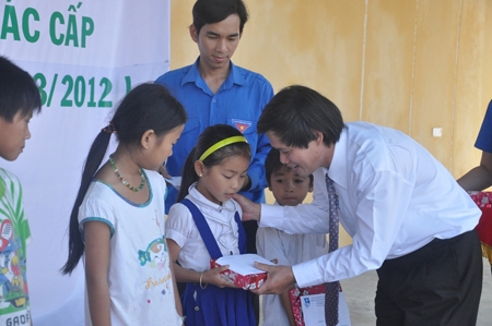 Lãnh đạo Ban Tuyên giáo Đảng ủy khối DN tặng quà cho trẻ em nghèo ở xã Bình Thạnh (Bình Sơn).          Ảnh: N.ĐỨC