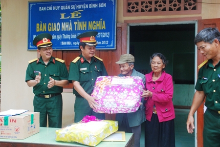 Thượng tá Nguyễn Ngọc Hóa - Chính trị viên - Ban CHQS huyện Bình Sơn tặng quà  cho gia đình ông Đinh Văn Danh trong lễ bàn giao nhà tình nghĩa.