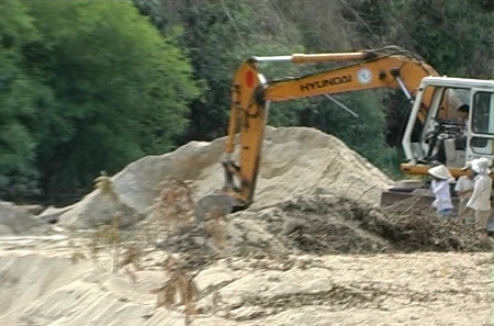 Một xe múc ngang nhiên khai thác cát trái phép trên sông Trà Câu