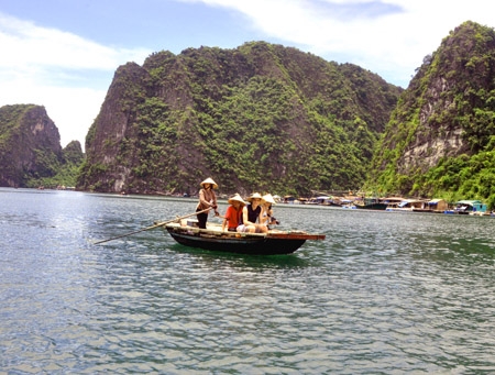 Du khách nước ngoài ngắm cảnh vịnh Hạ Long bằng thuyền chèo.