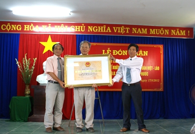 Ông Nguyễn Đăng Vũ – Giám đốc sở VHTT&DL tỉnh (bên trái) thừa ủy nhiệm của Chủ tịch UBND tỉnh, trao Bằng di tích lịch sử cấp tỉnh Khu lưu niệm cho lãnh đạo xã Hành Phước.