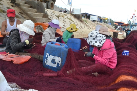 Chị em phụ nữ Lý Sơn vá lưới để kiếm thu nhập cho gia đình và giúp các tàu cá vươn khơi bám biển.