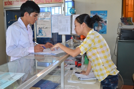 Phụ trách điểm BĐVHX Nghĩa Thắng Nguyễn Thị Thu Hiền hướng dẫn học sinh ghi phiếu để gửi hồ sơ xét tuyển.