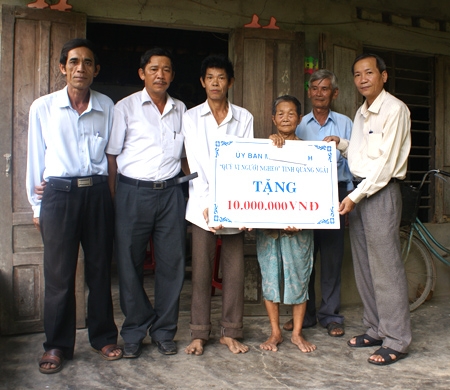 Ông Nguyễn Quốc Tịnh - Trưởng ban phong trào UBMTTQVN tỉnh (bên phải) trao 10 triệu đồng trích từ quỹ “Vì người nghèo” hỗ trợ hộ nghèo hoàn cảnh đặc biệt khó khăn ở huyện Tư Nghĩa.      