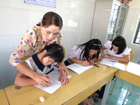 Cô Nguyễn Thị Xếp đang hướng dẫn học trò tô những nét chữ đầu tiên.