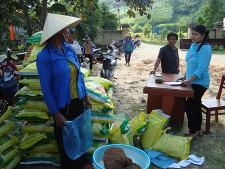 Sinh viên tình nguyện Nguyễn Thị Thu Hà (bên phải) cấp phát giống lúa, phân bón cho đồng bào dân tộc Hrê ở xã Ba Liên (Ba Tơ). Ảnh: t.nhị