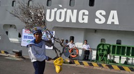   Một chiến sĩ vác cành đào lên tàu mang ra Trường Sa đón tết - Ảnh: Tuổi Trẻ