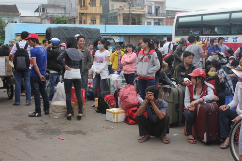 Nhiều hành khách vạ vật đứng ngồi chờ xe trong hàng tiếng đồng hồ