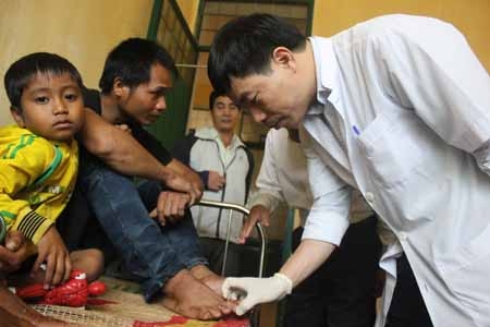 Phó Giáo sư, Tiến sĩ Nguyễn Hữu Sáu- Trưởng phòng nghiên cứu Khoa học, Bệnh viện Da liễu Trung ương khám cho các bệnh nhân mắc Hội chứng viêm da tại Trung tâm y tế huyện Ba Tơ