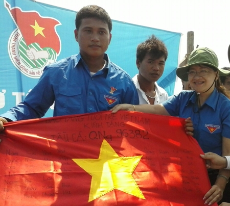Chị Hà Thị Anh Thư – Bí thư Tỉnh đoàn Quảng Ngãi trao cờ của Trung ương đoàn cho ngư dân Lý Sơn.