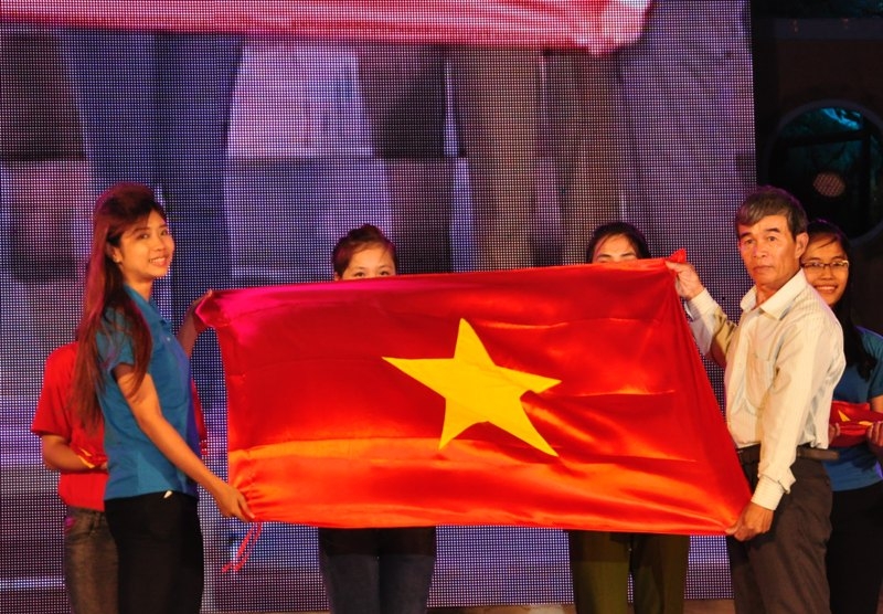 Ông Nguyễn Quốc Chinh - Chủ tịch Nghiệp đoàn cá xã An Hải nhận cờ của các bạn sinh viên trao tặng cho ngư dân