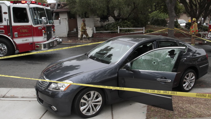  Chiếc xe bị hung thủ xả súng lỗ chỗ vết đạn ở cửa kính - Ảnh: Reuters