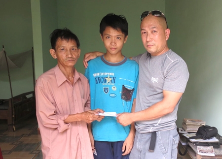 Anh Bình trao tiền giúp đỡ em Nguyễn Quốc Đạt, học sinh lớp 8, trường THCS Nghĩa Kỳ.