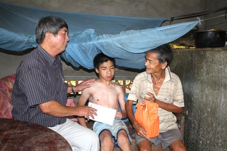 Ông Phan Thanh Long - Chủ tịch Hội NNCĐDC tỉnh tặng quà hỗ trợ cho một gia đình nạn nhân chất độc da cam