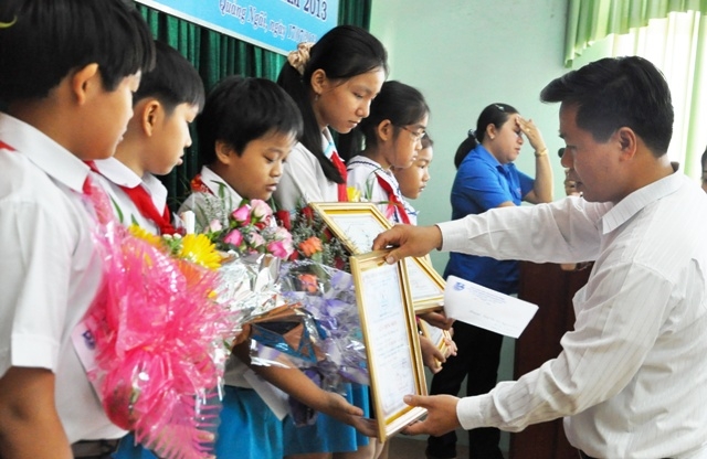 Anh Nguyễn Hoàng Hiệp - Phó Bí thư Thường trực Tỉnh đoàn trao thưởng cho các em học sinh