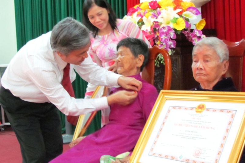 Phó Chủ tịch UBND tỉnh Lê Quang Thích gắn huy hiệu cho 2 mẹ VNAH Trần Thị A và  Huỳnh Thị Giàu.