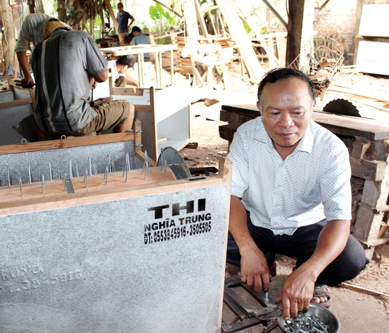  Ông Huỳnh Minh Thi bên chiếc máy tuốt lúa mang tên “Thi-Nghĩa Trung”.