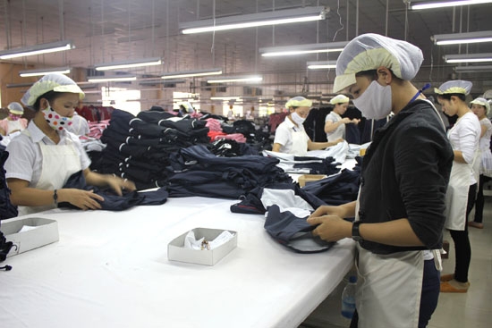 Công nhân Công ty TNHH XNK Thuyên Nguyên đang sản xuất hàng may mặc.