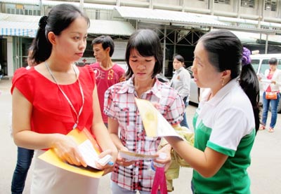 Nhân viên bưu điện (bìa trái) hướng dẫn dịch vụ phát trả kết quả xét nghiệm đến các sản phụ khoa.