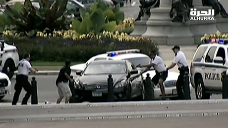 Chiếc xe màu đen của nghi phạm bị cảnh sát bao vây.
