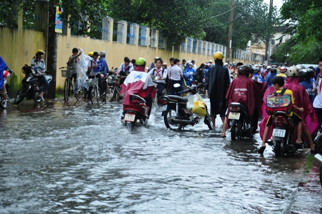  Tuyến đường Nguyễn Thị Minh Khai ngập nước khiến phụ huynh chờ đón con đi học về phải đứng chờ trong nước.