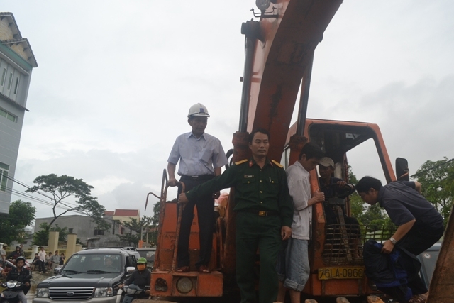 Đồng chí Chủ tịch UBND tỉnh di chuyển bằng xe máy đào qua các vùng nước ngập