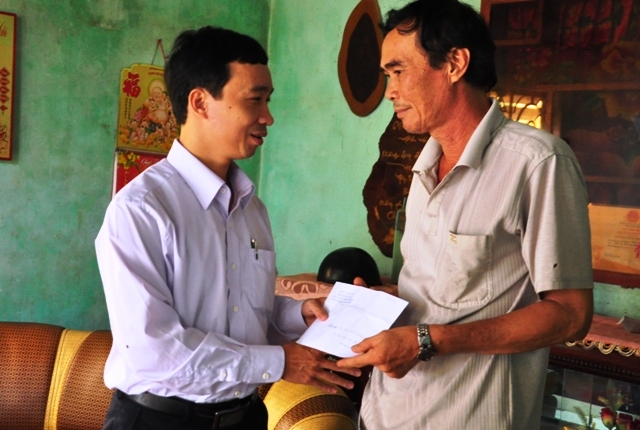 Đồng chí Huỳnh Đức Minh- Phó Tổng Biên tập Báo Quảng Ngãi trao số tiền do bạn đọc Báo Quảng Ngãi đóng góp cho gia đình em Phạm Quốc Vương 