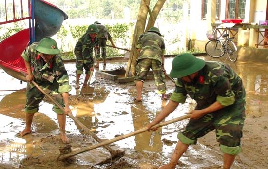 Cán bộ, chiến sĩ Trung đoàn 887 giúp dân khắc phục hậu quả mưa lũ.